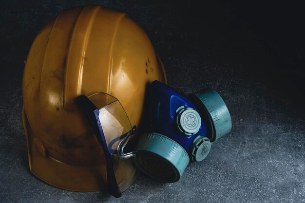 Respirator goggles and miner protective helmet on concrete floor