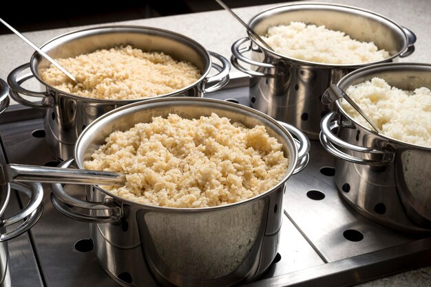 Restaurant buffet set up with rice cookers, beans, chicken and meat.