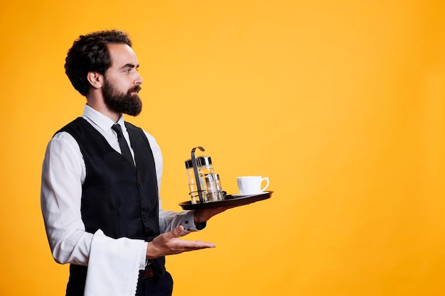 Restaurant butler points aside with tray