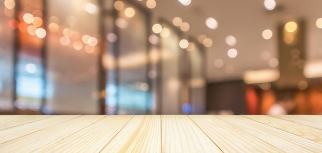 Photo restaurant interior with customer and wood table top over blur abstract background with bokeh light