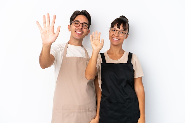 Restaurant mixed race waiters isolated on white background saluting with hand with happy expression