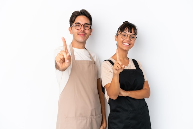 Restaurant mixed race waiters isolated on white background showing and lifting a finger