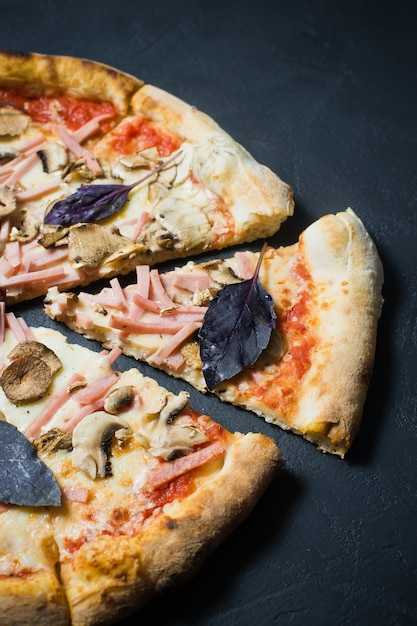 Restaurant pizza with ham, mushrooms and Basil. 