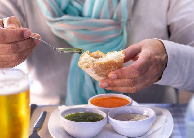 At the restaurant table a woman tastes one of the
typical sauces of the Canary Islands, called "mojo"