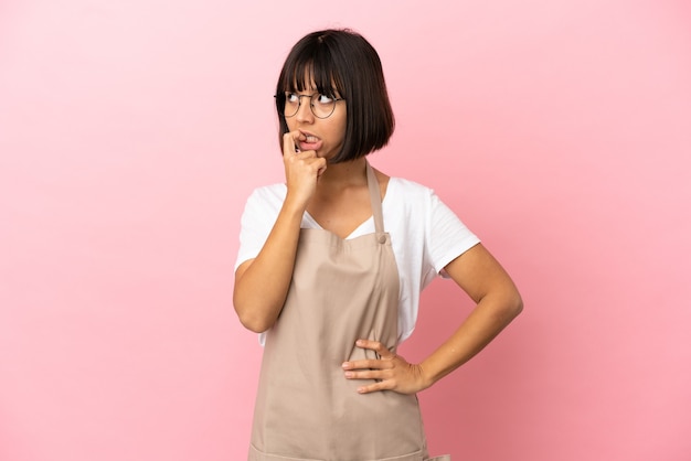 Restaurant waiter over isolated pink background nervous and scared