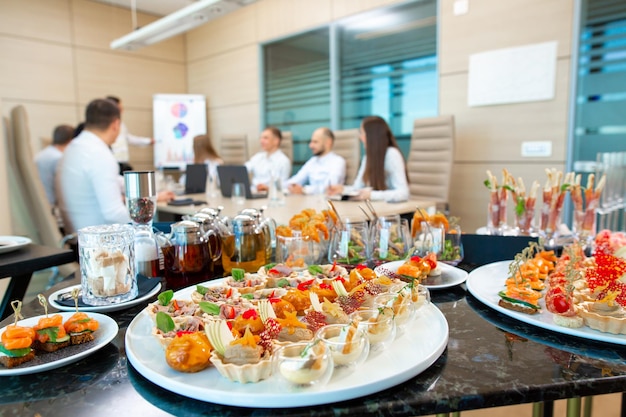 A restaurant waiter serves an offsite banquet in the officexA