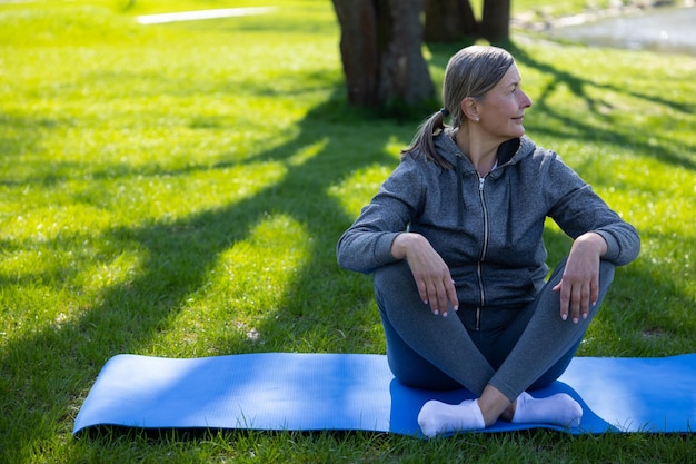 Resting Woman in sportswear resting on the yoga mat after the class