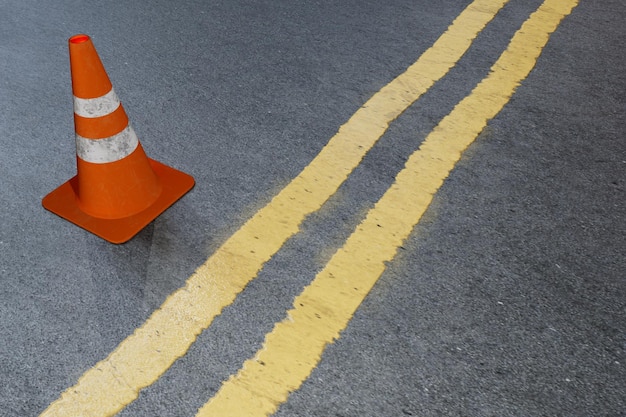 Restriction on the road markings and a road cone on a gray background 3D render