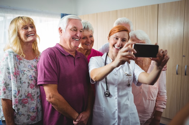 Retired people taking a selfie with a nurse