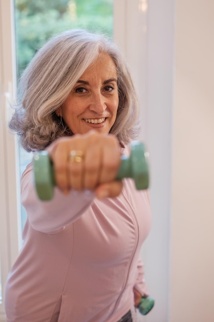 Retired woman doing exercises at home to keep the body healthy Concept body care healthy life exercise routine