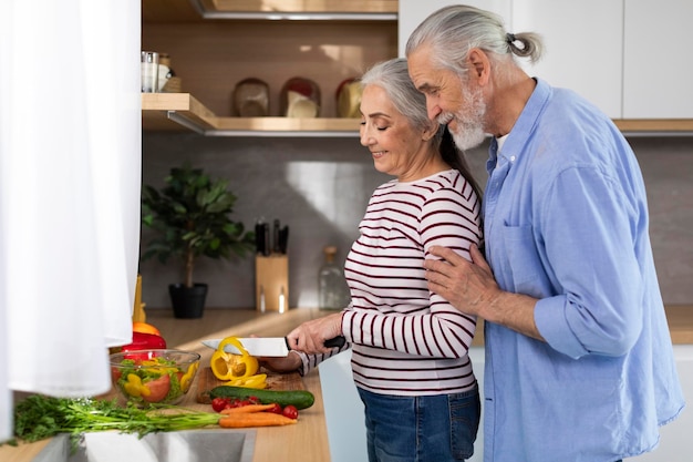 Retirement Leisure Smiling Senior Spouses Cooking Lunch Together In Kitchen Interior