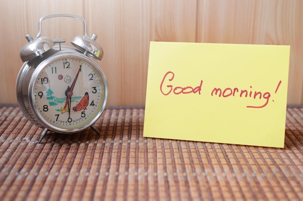 Retro alarm clock next to the paper that says good morning