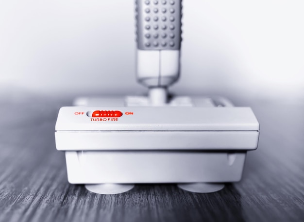 Retro arcade joystick with red turbo button bokeh background