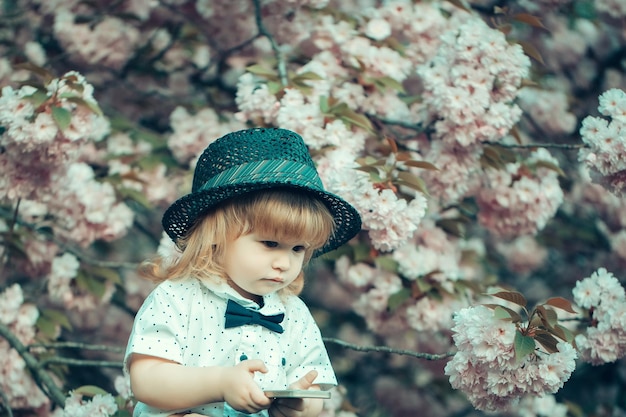 Retro boy with phone in blossom