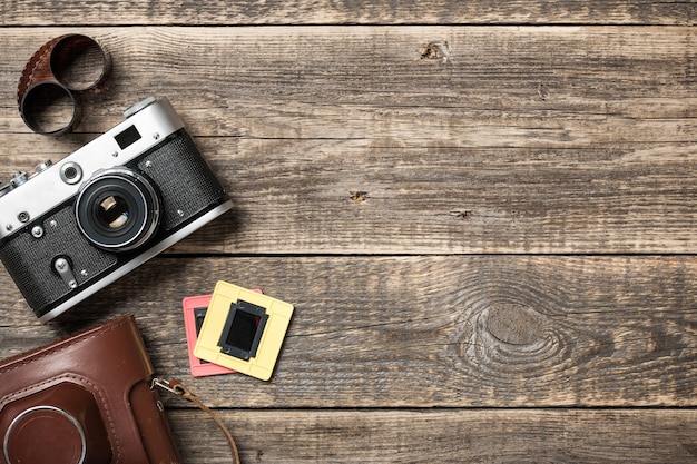 Retro camera and film on wooden background