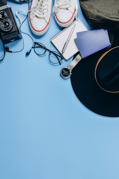 Retro camera, hat, backpack, eyeglasses, clock, pen, passport, shoes and notepad. 