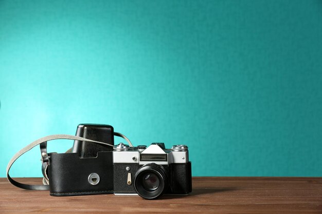 Retro camera on table on green background