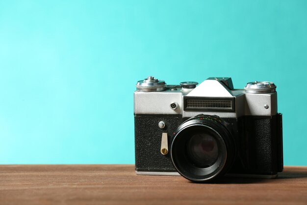 Retro camera on table on green background