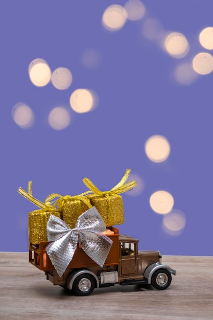 Retro car with gifts on a colored background. Vertical format with copy space. Festive concept