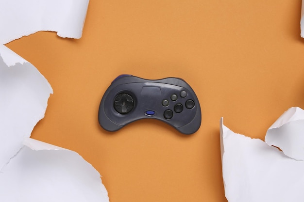 Retro gamepad and white torn paper sheets on beige background Minimalistic background Top view Copy space