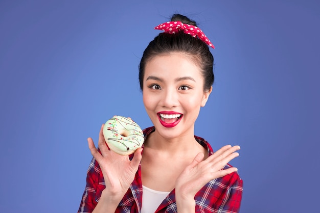 Photo retro joyful woman enjoy sweets, dessert standing over blue background.