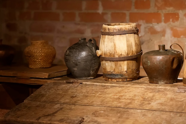 Retro jugs and a barrel in an old brick basement.