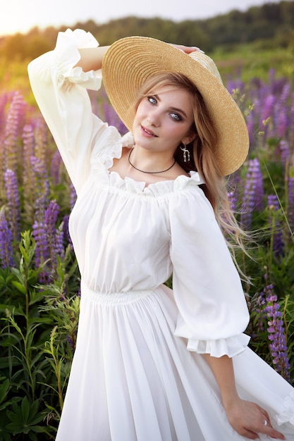 A retro lady enjoys the beauty of a blooming lupine field