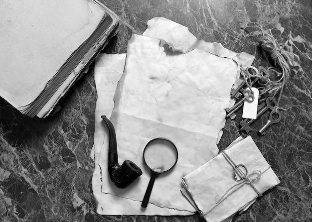 Retro papers and book on detective work table with tools background