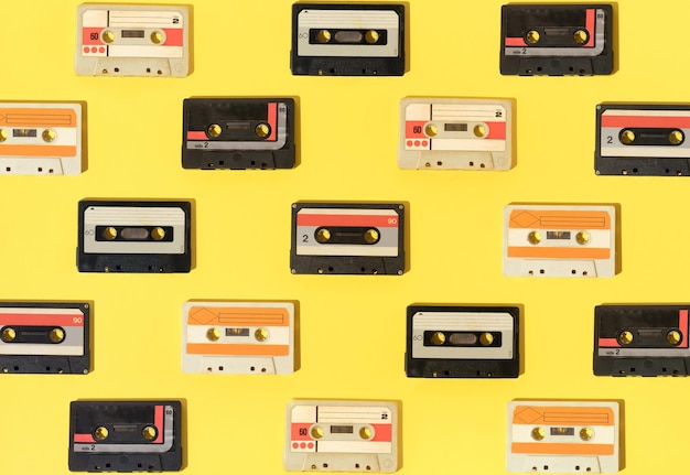 Retro pattern with audio cassestes on yellow background