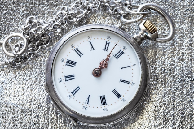 Retro pocket watch on silver fabric close up