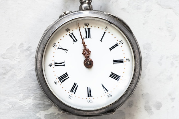 Retro pocket watch on white concrete close up