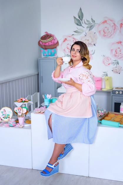 Retro style girl drinking tea in the kitchen