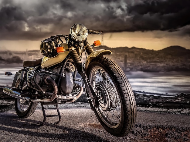 A retro-style sports motorcycle stands on Street against a cloudy sky