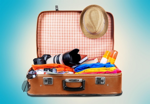 Retro suitcase with travel objects  on background