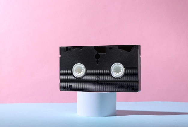 Retro video cassette on the stand Blue pink pastel background