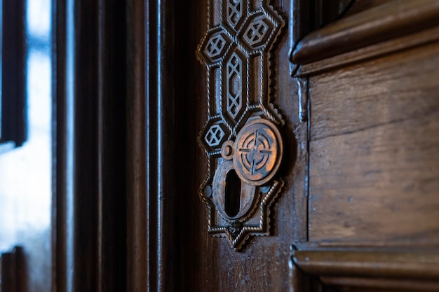 Retro vintage wooden door with brass copper keyhole Old metal keyhole