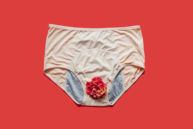 Photo reusable period underwear with rose flower on red background absorbent and affordable period panties to absorb menstrual fluid