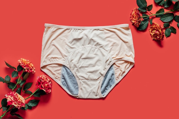 Photo reusable period underwear with rose flower on red background absorbent and affordable period panties to absorb menstrual fluid