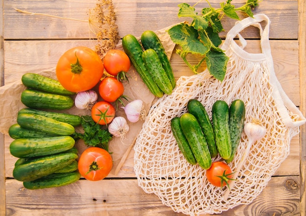 Reusable shopping bag string bag made of recycled materials on a wooden table among fresh vegetables No plastic Ecofriendly lifestyle