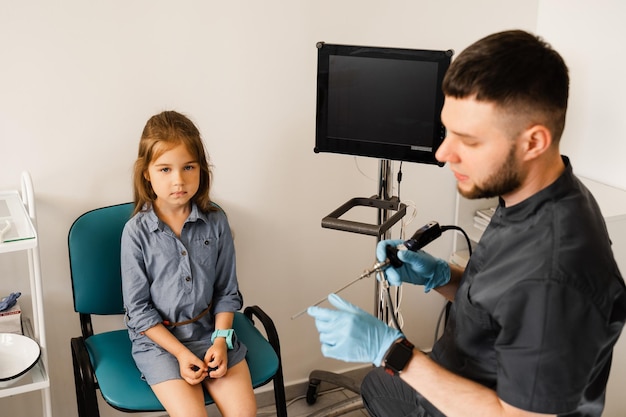 Rhinoscopy of child nose Consultation with doctor Children otolaryngologist calms child before procedure of rhinoscopy of nose