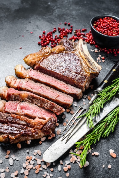 Ribeye steak on the bone with salt and pepper. Grilled Beef meat.