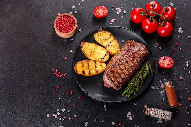 Ribeye steak with potatoes, onions and cherry tomatoes. Juicy steak with flavored butter