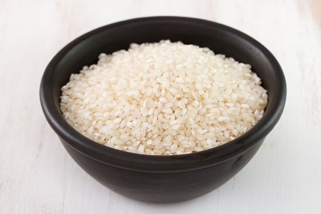 Rice in black bowl on white table