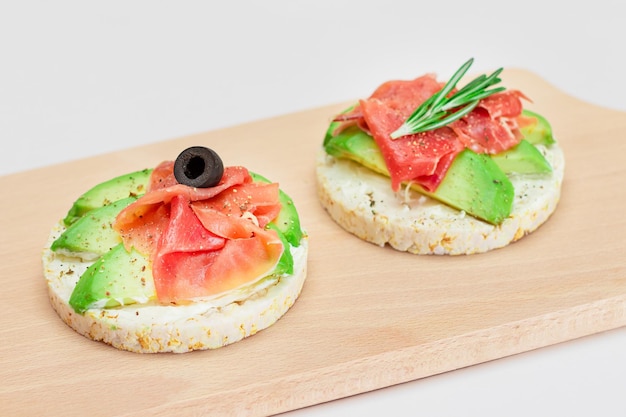 Rice cake sandwich with avocado jamon olives and rosemary