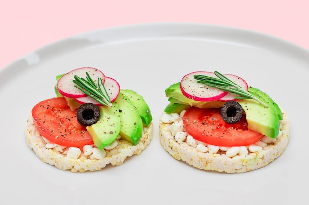 Rice cake sandwich with avocado tomato cottage cheese olives and radish