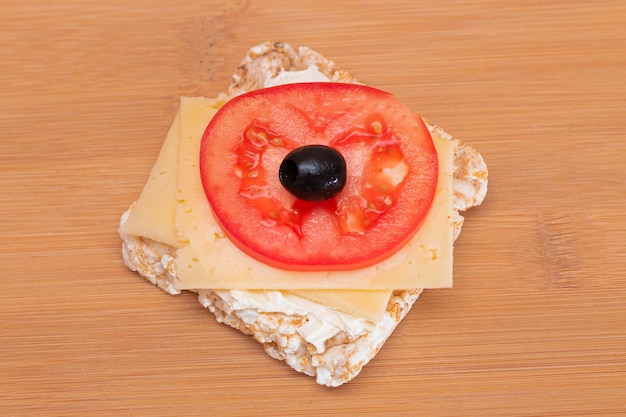 Rice cake sandwich with tomato cheese and olives