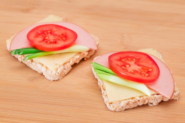 Rice cake sandwich with tomato sausage green onions and cheese