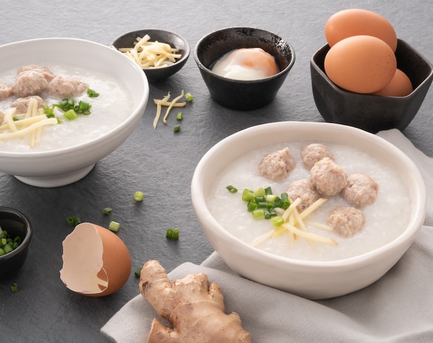 Rice congee with minced pork in white bowl. Bowl of rice porridge with soft boiled egg. Asian breakfast