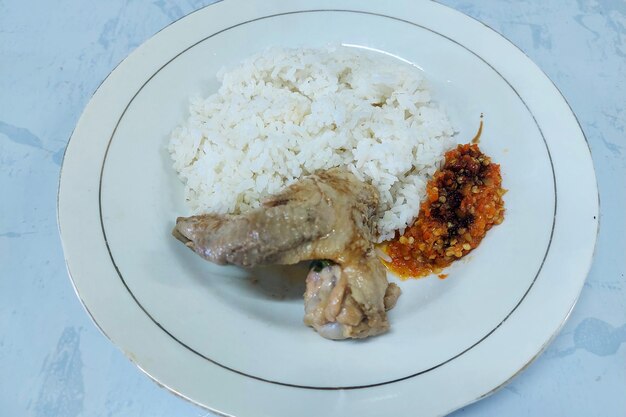 Photo rice mixed with fried fish and tempeh vegetables on a white plate on the table