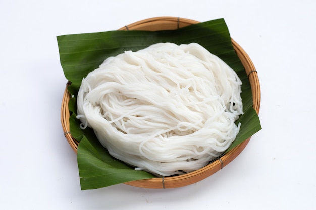 Rice noodle in bamboo basket on white background.